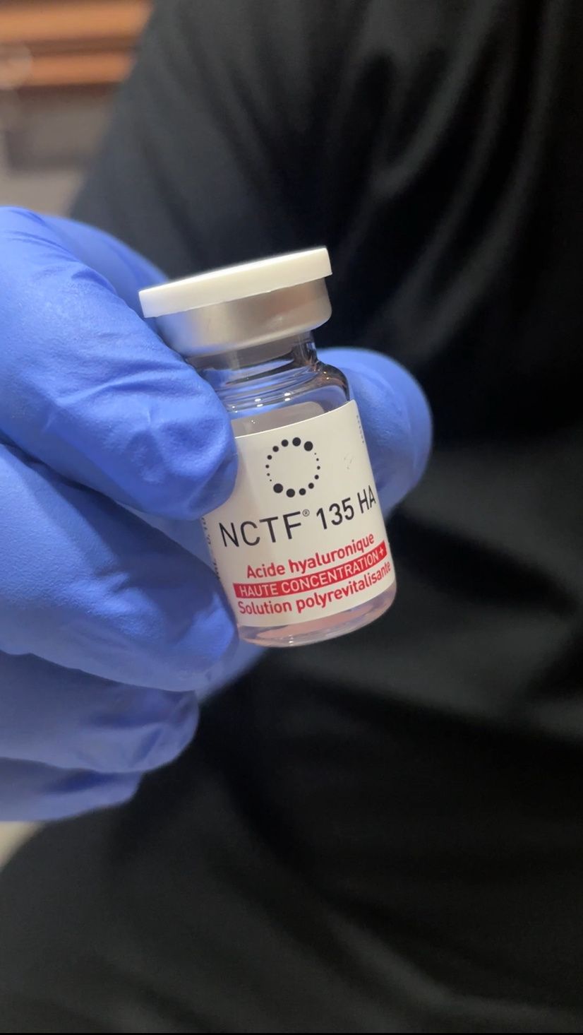 Mano con guante sostiene un vial de NCTF-135HA